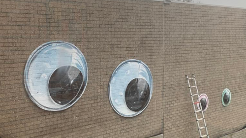 Vrolijke gezichtjes van Jan Is De Man op muur van Anna van Rijn College