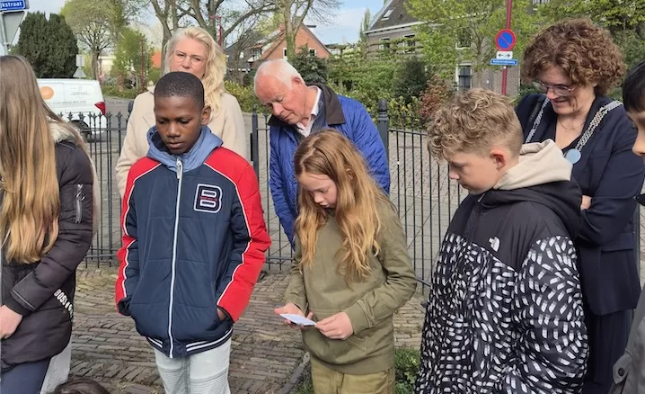 Kinderen De Vleugel bij oorlogsmonument met burgemeester Beukering