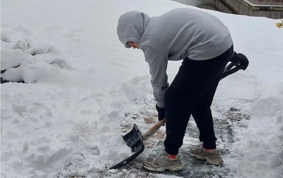 cals leerling ruimt sneeuw op voor gymles