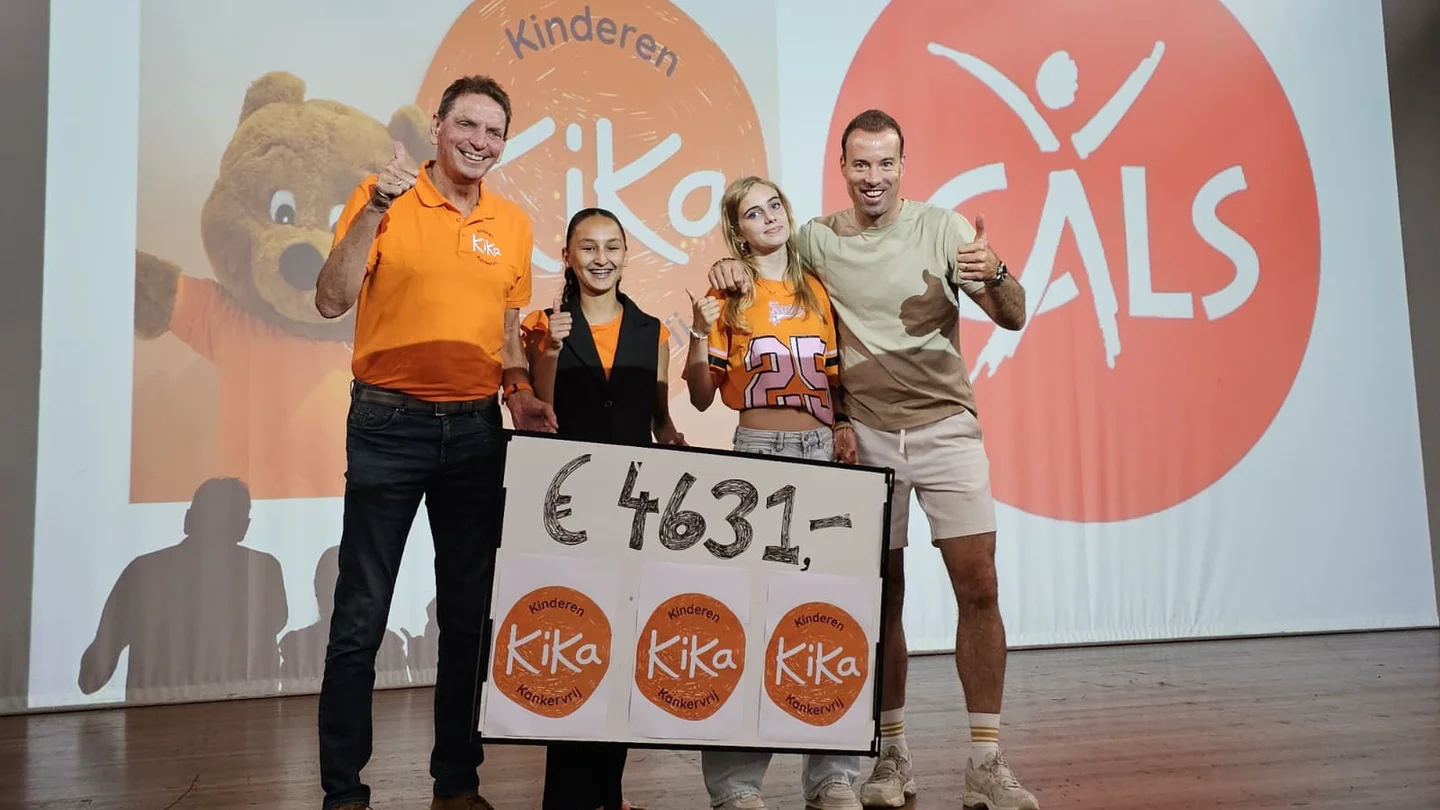 Leerlingen van het Cals College overhandigen de cheque aan een vertegenwoordiger van KiKa